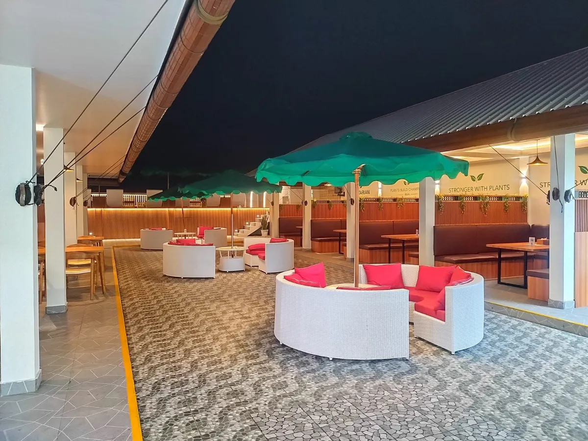Rooftop lounge at Cleon Bistro with green parasols and white rattan sofas